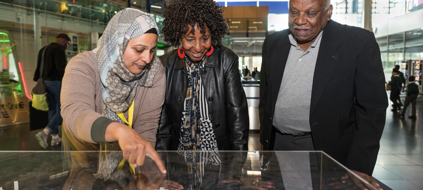 Engagement manager shows two members of the public a model of a station