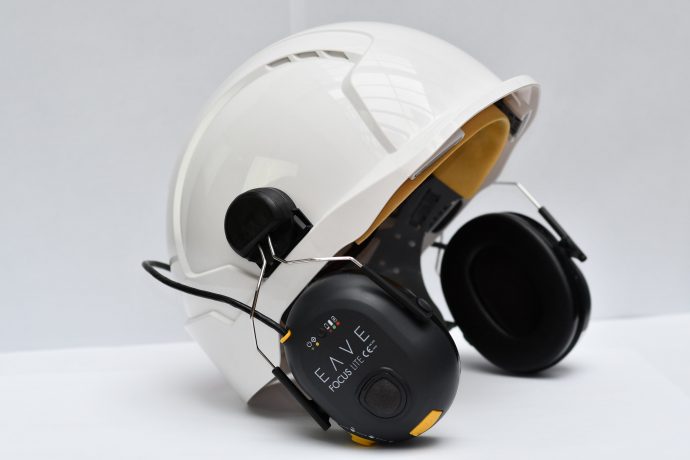 Construction hard hat with ear defenders attached to side.