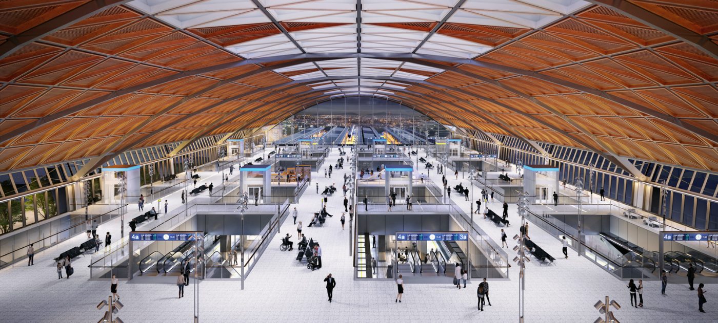 CGI image of the interior of a station under a large roof arch with a concourse below.