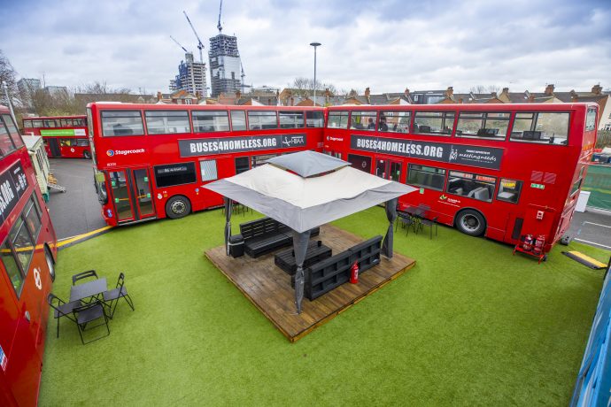 Converted buses parked in a square offering space for homeless people to live and train.
