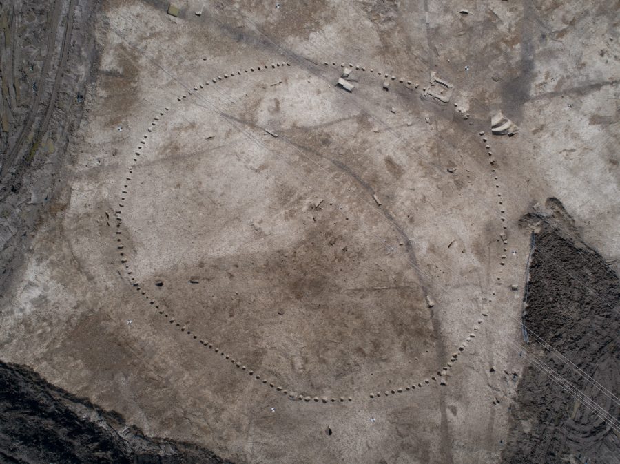 Aerial view on a large archaelogically excavated area revealing a circle of post holes about 65m in diameter.