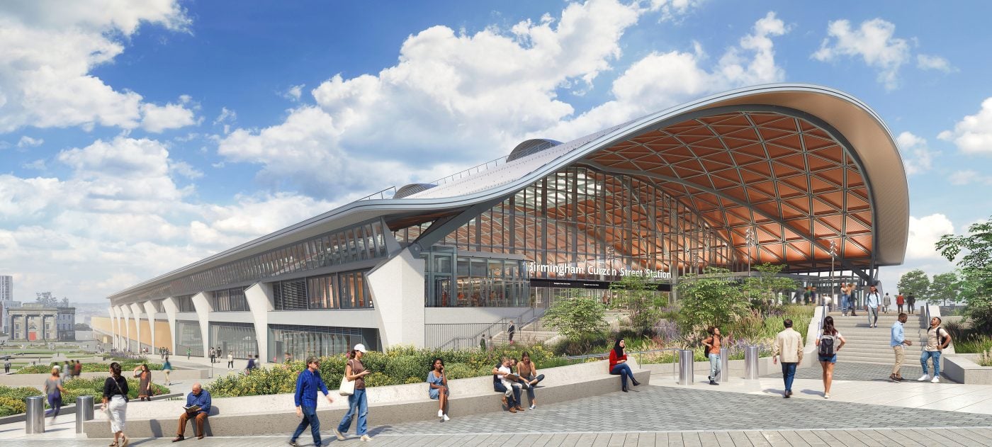 Train station with curved roof and people outside