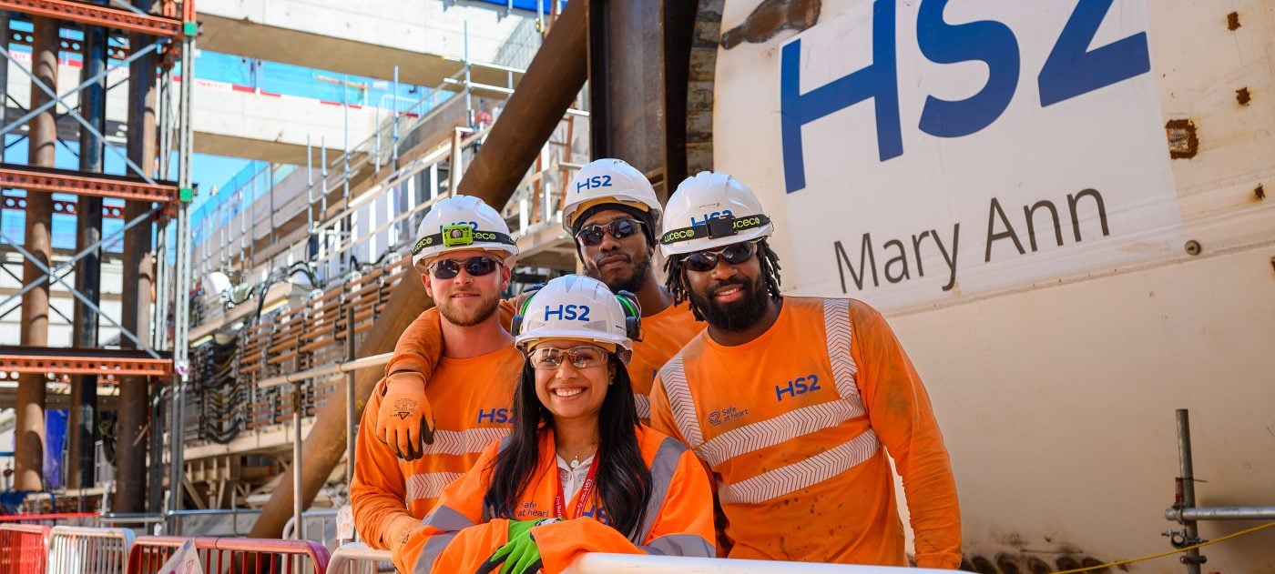 Group of people standing in front of a tunnel boring machine